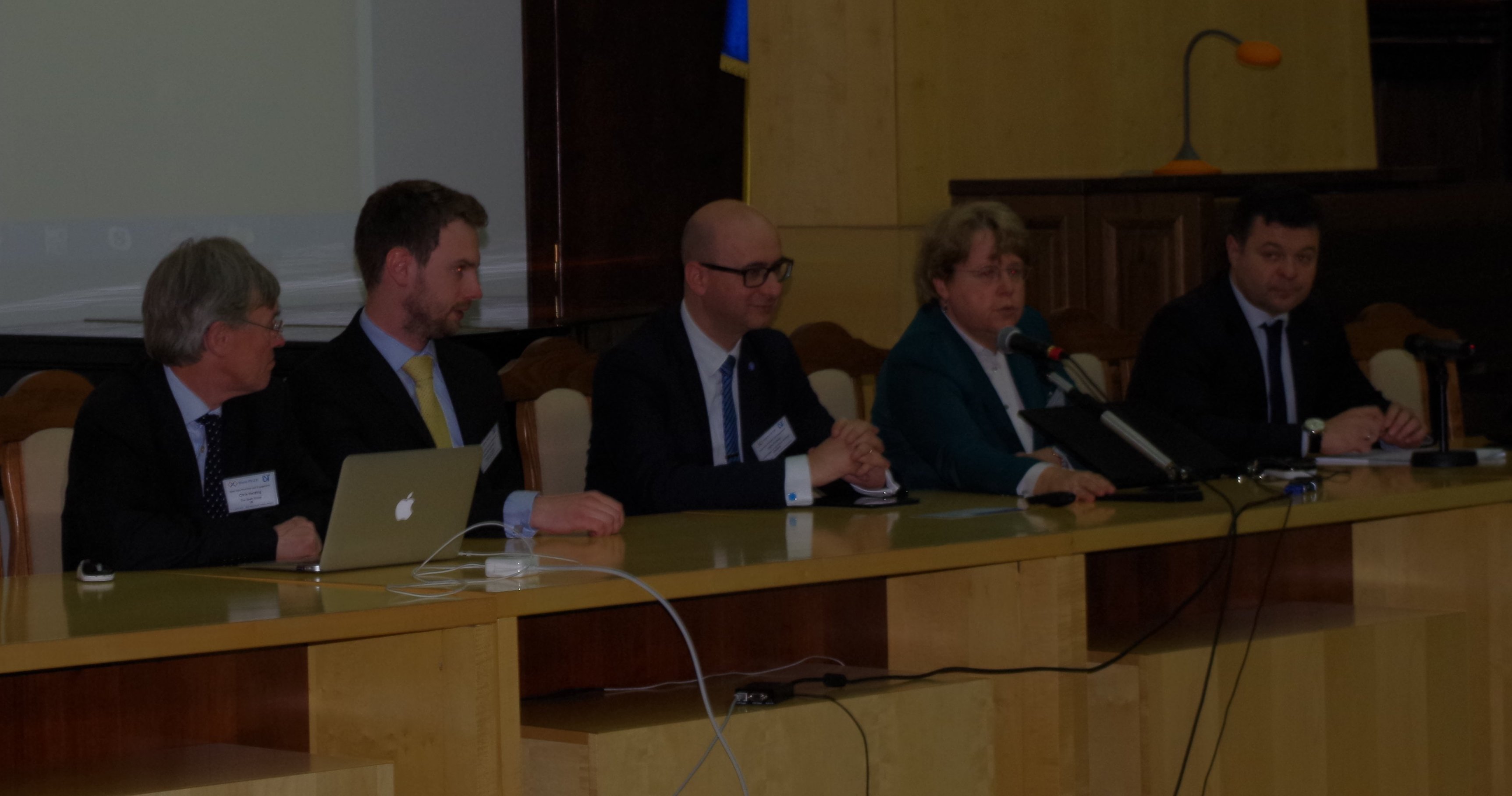 5 people sitting on a dais, readyto address the room