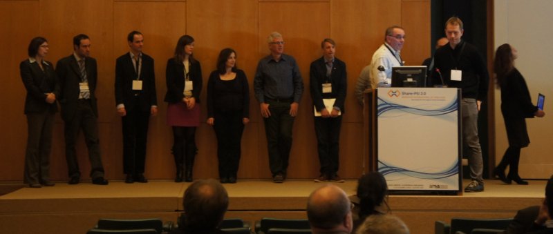 A row of 11 people on stage waiting to make their bar camp pitches