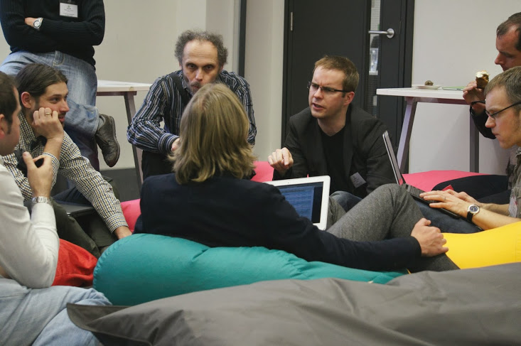A group of people sitting on bean bags during the bar cam session. Jeremy Tandy is making a point